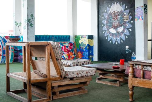 a room with a wooden chair and a table at El Mural Backpackers in Tarapoto