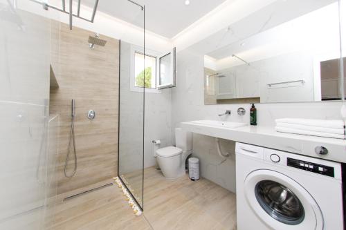 a bathroom with a washing machine and a sink at Olivia’s House in Kavos