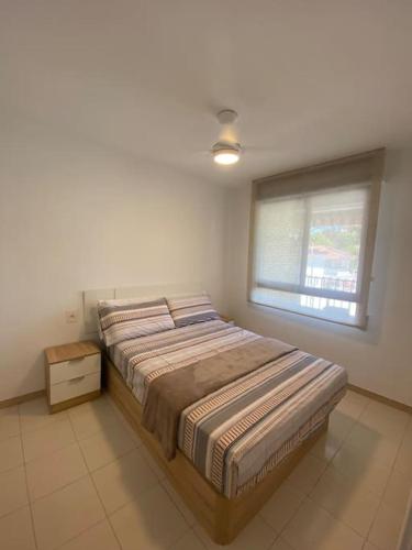 a bedroom with a bed and a window in a room at Apartamentos Cumbremar en Benicàssim in Benicàssim