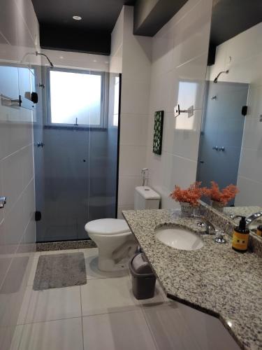 a bathroom with a toilet and a sink and a shower at Apto Moderno Teresopolis in Teresópolis