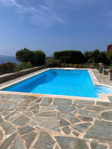 a swimming pool with a stone floor and blue water at Ines’s Dream in Stelida
