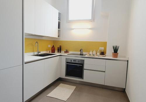 a kitchen with white cabinets and a sink at Casa con terrazza esclusiva su Nardò in Nardò