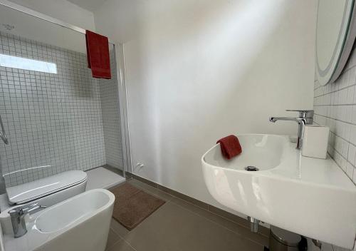 a white bathroom with a sink and a toilet at Casa con terrazza esclusiva su Nardò in Nardò