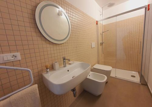 a bathroom with a sink and a toilet and a mirror at Casa con terrazza esclusiva su Nardò in Nardò