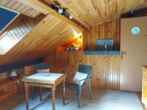 a room with a wooden ceiling with a table and chairs at NOMAD ALP B&B in Marthod