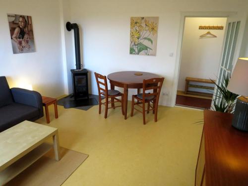 een woonkamer met een tafel en stoelen en een fornuis bij Ferienwohnung Butterbirne in Niedergörsdorf