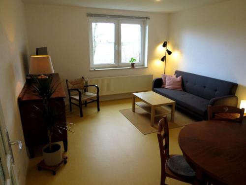 een woonkamer met een blauwe bank en een tafel bij Ferienwohnung Butterbirne in Niedergörsdorf