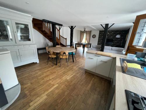 a kitchen and living room with a table and chairs at Les gîtes de Madline, Le gîte du prieuré in Saint-Georges-de-Gréhaigne