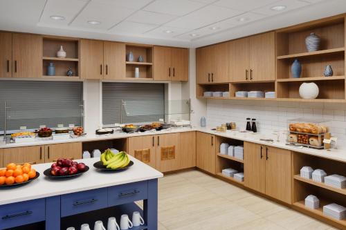a large kitchen with wooden cabinets and fruits on a counter at Hyatt Place across from Universal Orlando Resort in Orlando