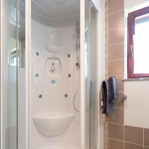 a bathroom with a shower and a sink at Tinčeva hiša in Kanal