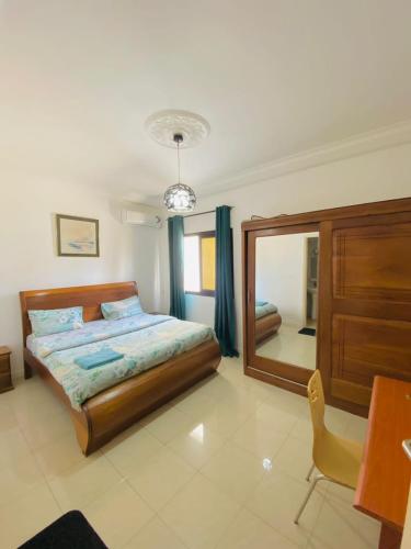 a bedroom with a bed and a large mirror at Appartement xandra 2 in Dakar