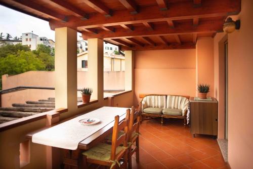 a porch with a table and chairs on a balcony at Casa Nina con terrazza in Dorgali
