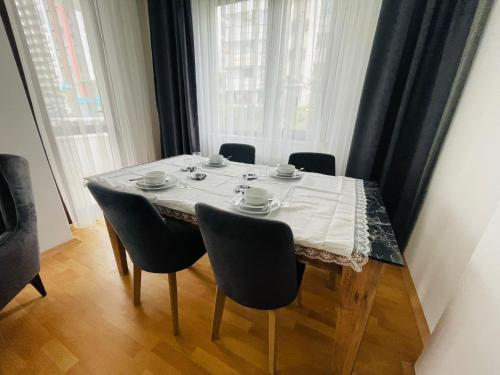 a dining room table with chairs and a white table cloth at IVORY SUİTE ACCOMMODATION in Trabzon