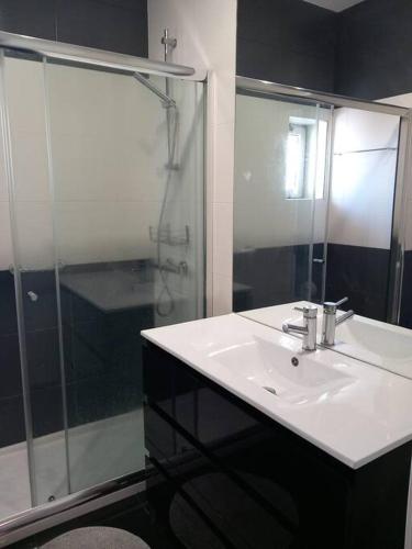 a bathroom with a sink and a shower at Vila Mar Apartment in Vila do Conde