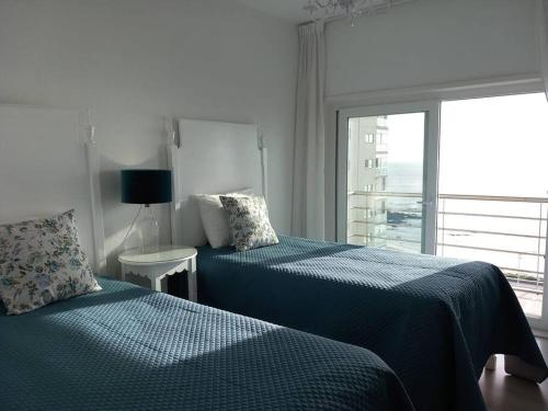 een slaapkamer met 2 bedden en een raam met uitzicht bij Vila Mar Apartment in Vila do Conde