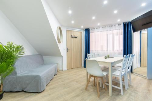 een woonkamer met een tafel, stoelen en een bank bij Nets Inn - Botzaris in Parijs
