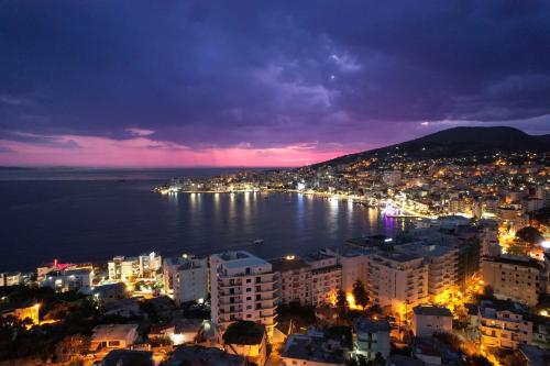 a view of a city at night with the water at Villa All Season in Sarandë