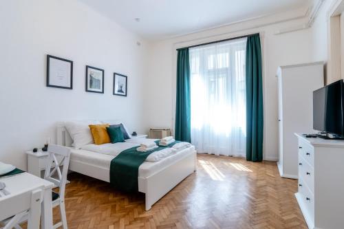 een witte slaapkamer met een bed en een raam bij Budafoki Residence in Boedapest