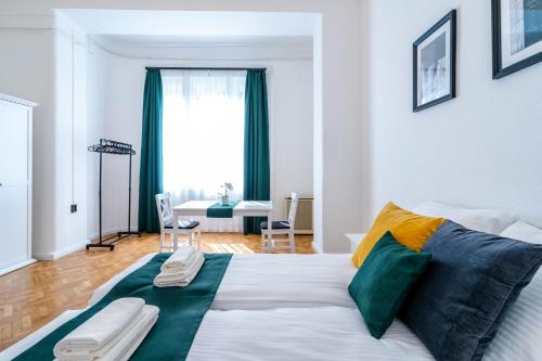 een slaapkamer met een groot wit bed met kleurrijke kussens bij Budafoki Residence in Boedapest