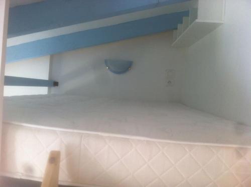 une cuisine avec une étagère sur le mur dans l'établissement Ardèche, studio indépendant dans jardin, à Chomérac