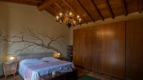 um quarto com uma cama com um galho de árvore na parede em Ca' di Max em Giucano