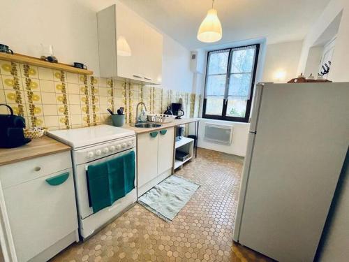 a kitchen with a refrigerator and a sink in it at Appartement messier mezzanine in Senones