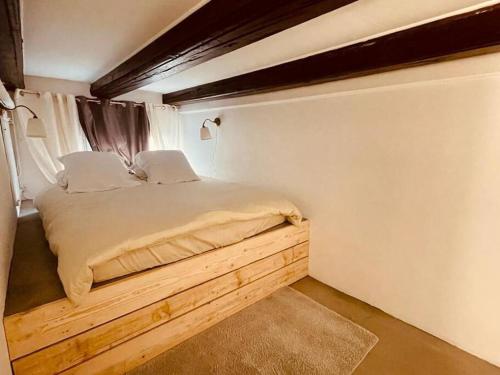 1 dormitorio con 1 cama con plataforma de madera en Appartement messier mezzanine en Senones