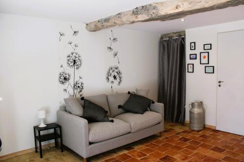 a living room with a couch and flowers on the wall at LE CLOS DES PIERRES ROUGES in Burgy