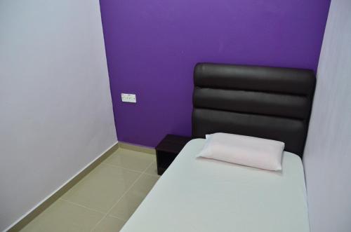 a bedroom with a bed and a black chair at Deena Hotel Bajet in Gua Musang
