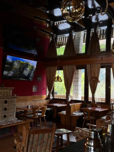 a restaurant with wooden tables and chairs and a large window at Monterovere in Albergo Monte Rovere