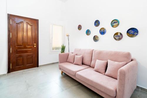 アルメリアにあるCasa Bonitaの壁に皿が飾られたリビングルームのピンクのソファ