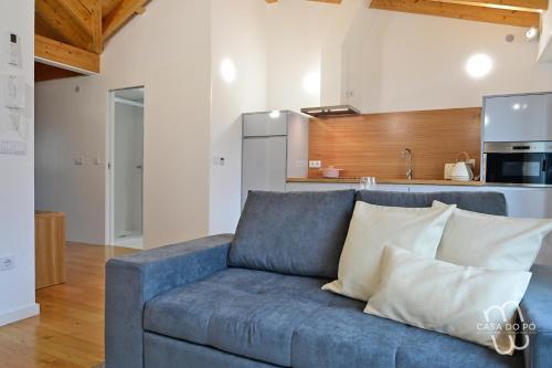 a blue couch in a living room with a kitchen at Casa do Pó, Alojamento Local in Lamego