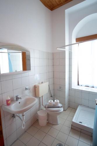 a white bathroom with a sink and a toilet at Gkoura hotel in Sirako