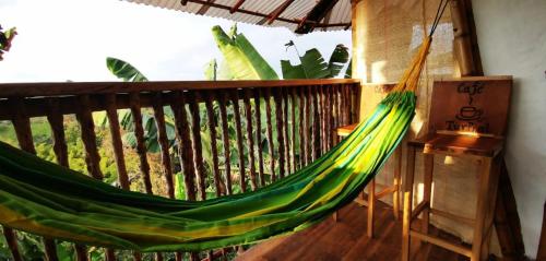 a green hammock on a balcony with plants at El Turpial in Jericó