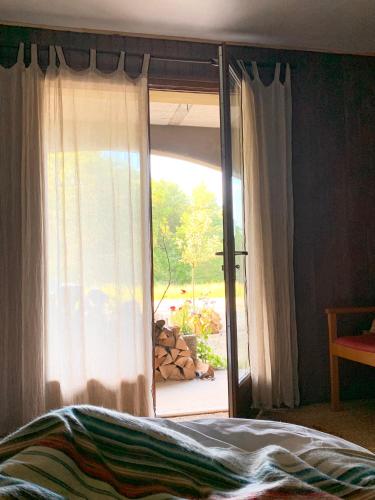a bedroom with a window with a view of a yard at le chalet de Plainpalais in Les Déserts