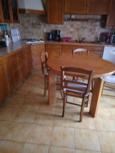 une cuisine avec une table et des chaises en bois dans l'établissement Maison détente classée meublé 3 étoiles, à Caylus