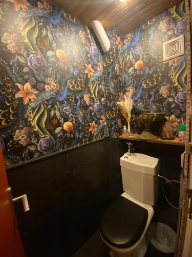 a bathroom with a floral wallpaper with a toilet at Hôtel Restaurant "La Petite Auberge" in Bourg-Saint-Maurice