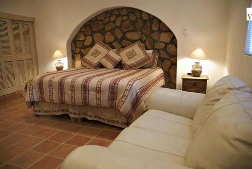 a bedroom with a large bed and a couch at Villa Turnage in Cabo San Lucas