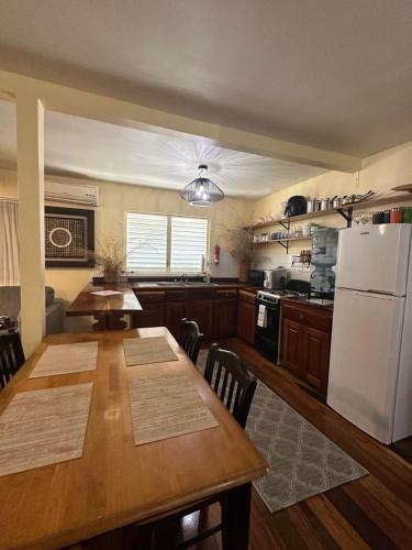 uma cozinha com uma mesa e um frigorífico branco em The Coral Casa em Caye Caulker