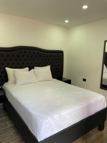 a bed with white sheets and pillows in a room at Cabinas Vista Al Golfo in Monteverde Costa Rica