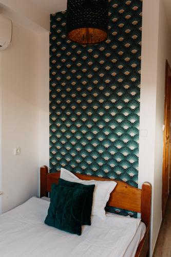 a bedroom with a bed with a blue wall at Palma Vendégház in Szeged