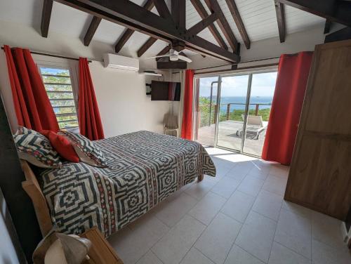 une chambre avec un lit et une vue sur l'océan dans l'établissement Villa Perséides, à Deshaies