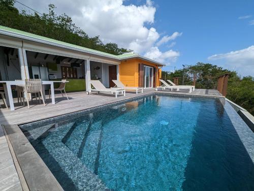 une piscine devant une maison dans l'établissement Villa Perséides, à Deshaies