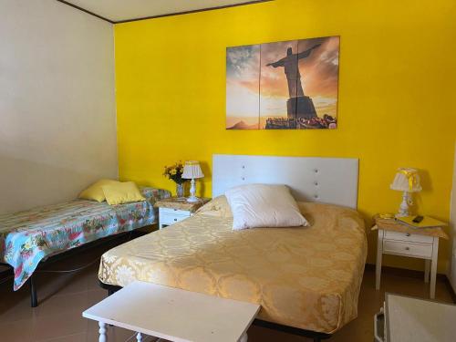 una camera con due letti e un dipinto sul muro di Pousada Copacabana Praia - AFFITTACAMERE - Casa Vacanza a Porto Sant'Elpidio a Porto SantʼElpidio