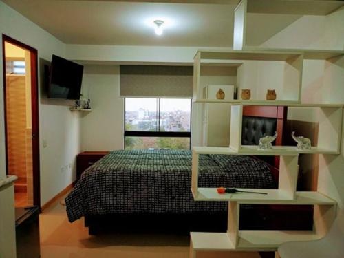 ein Schlafzimmer mit einem Bett und einem Bücherregal in der Unterkunft Hospedaje Libertador San Martín - Dpto. entero # 2 in Víctor Larco Herrera
