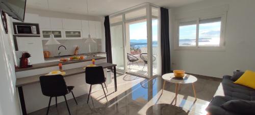 a kitchen and a living room with a table and chairs at Apartment Lantana Hvar in Hvar