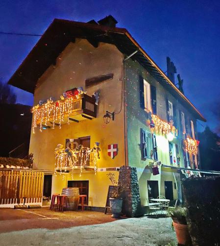 a house with christmas lights on the side of it at Hôtel Restaurant "La Petite Auberge" in Bourg-Saint-Maurice