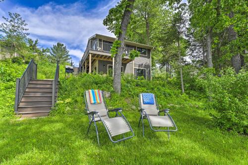 two chairs sitting in the grass in front of a house at Happys Haven Cabin with Gas Grill and Fire Pit! in Lodi