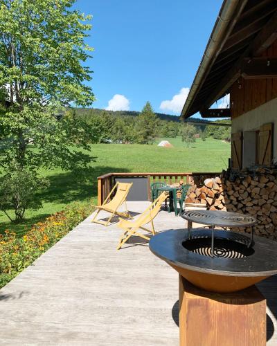 a patio with a grill and a table and chairs at le chalet de Plainpalais in Les Déserts