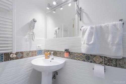 bagno bianco con lavandino e specchio di Vin Novo Rooms & Apartments a Firenze